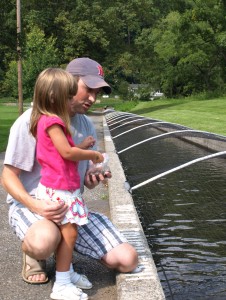 Eric Molitoris and his daughter, Avery, feed the trout at the Fish Hatchery.